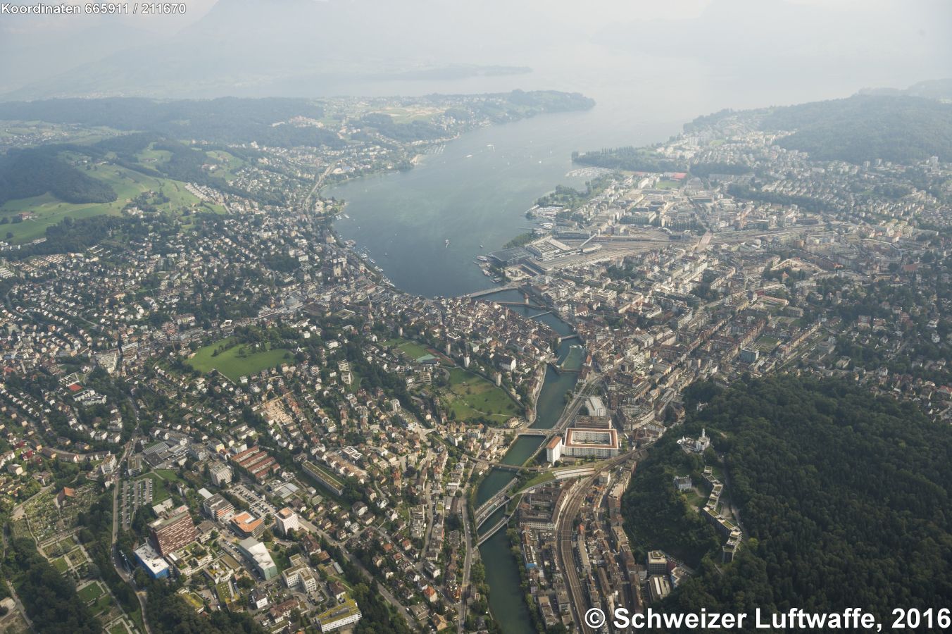 Blick Reuss-aufwärts zum Vierwaldstättersee. Kapellbrücke im Bildzentrum, am See: KKL, Universität und Bahnhof. Markant ist die rechteckige Wohnsiedlung 'Sentihof' (Position 2'665'269.81, 1'211'647.48) links der Reuss mit fast 300 Wohnungen und über 600 Einwohnern. Davor liegt das Tunnelportal zum Sonnenbergtunnel der A2/E35. Auf der Anhöhe im Wald rechts: Château Gütsch.